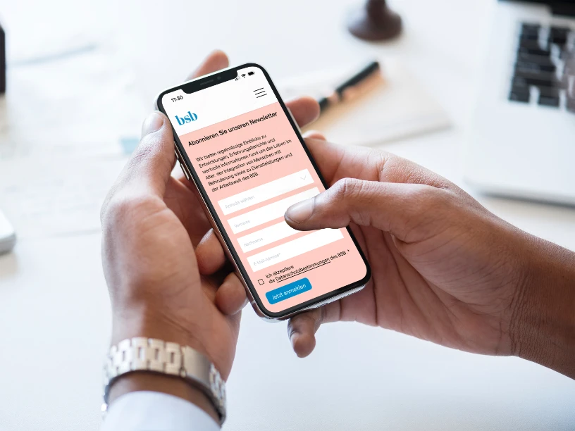 Smartphone von Händen gehalten mit Anmeldeformular Newsletter